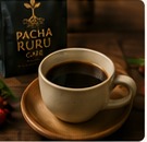 Taza de café servida junto a la marca Pacha Ruru